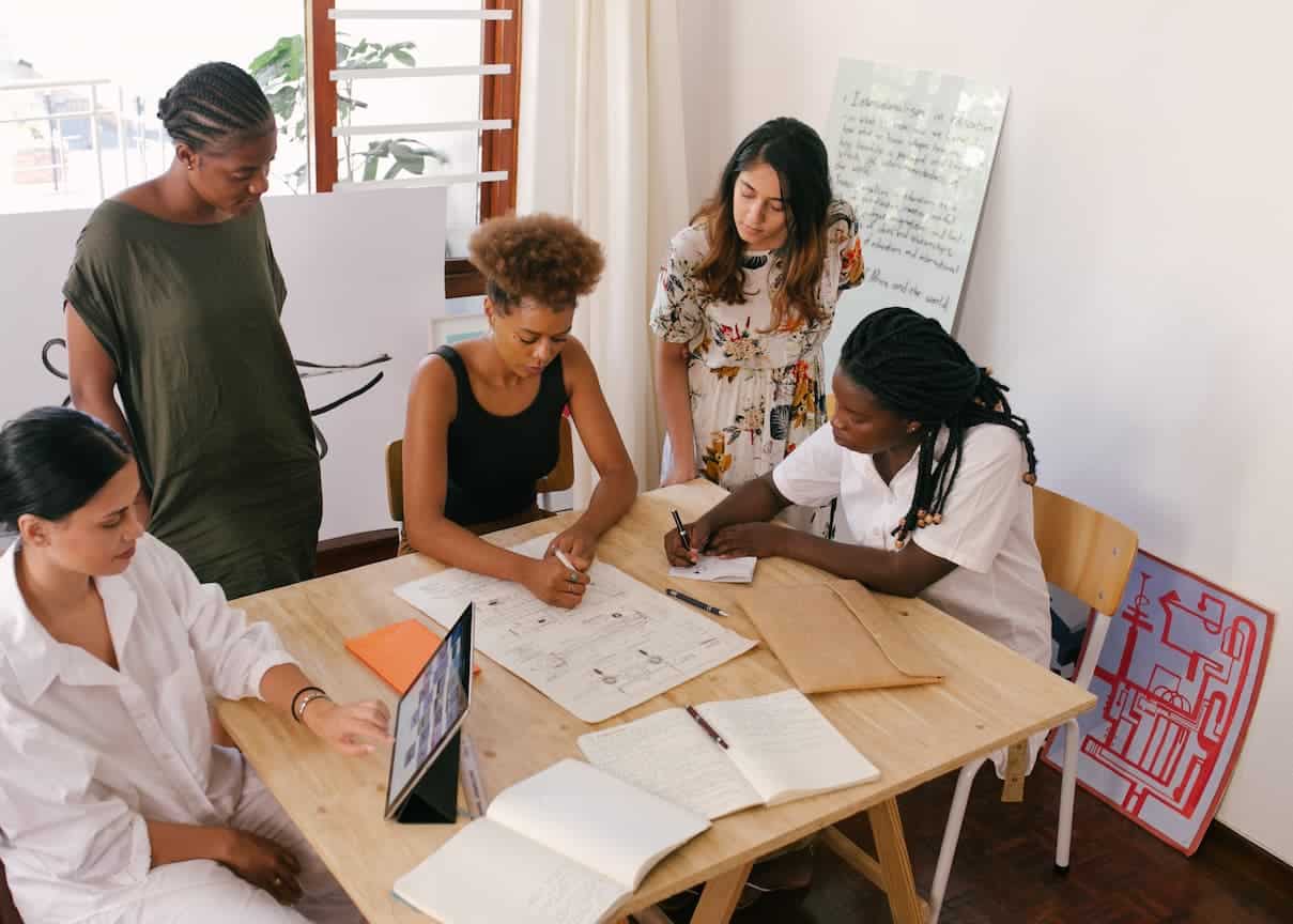gruppo di imprenditrici a lavoro cinque donne che lavorano sedute ad un tavolo